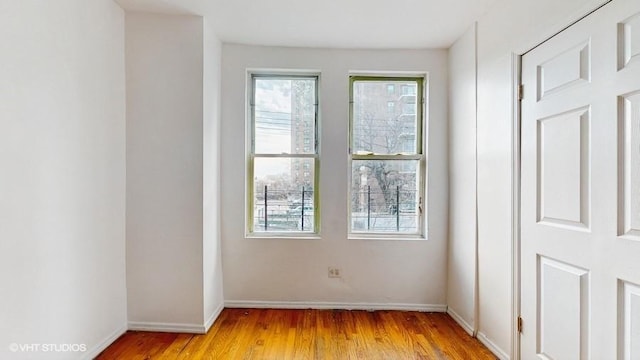 empty room featuring baseboards and light wood-style floors