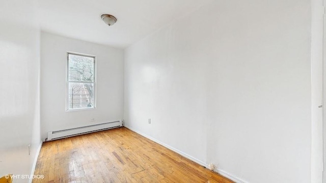 unfurnished room with light wood-type flooring, baseboards, and a baseboard radiator