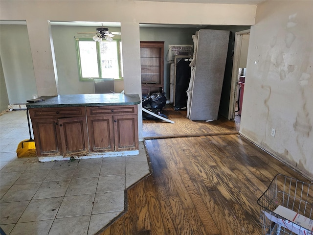 kitchen with dark countertops, a ceiling fan, and wood finished floors