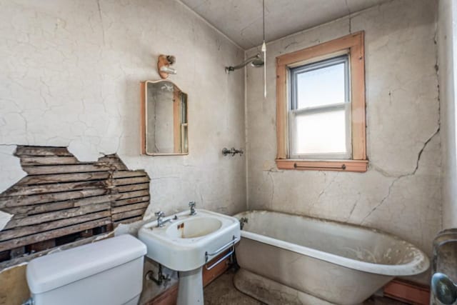 full bath with toilet and a tub to relax in