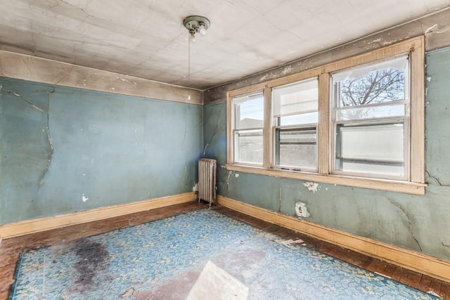 spare room featuring baseboards and radiator heating unit