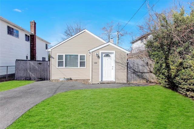 bungalow-style house featuring a front yard and fence