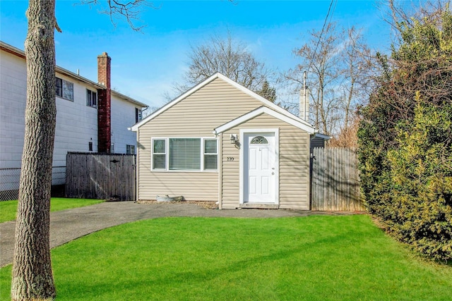 view of front facade featuring a front yard and fence