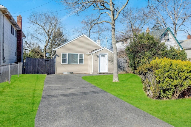 bungalow-style house featuring a front yard, fence, and driveway