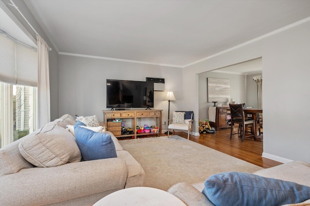 living room featuring wood finished floors, baseboards, and ornamental molding