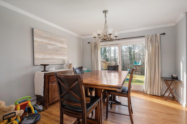 dining space with a notable chandelier, light wood-type flooring, and ornamental molding