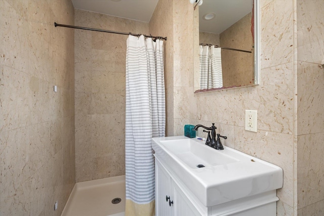 bathroom with vanity, tile walls, and a tile shower