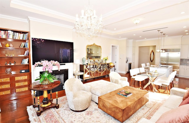 living area featuring ornamental molding, a tray ceiling, and wood finished floors