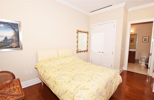 bedroom featuring visible vents, dark wood finished floors, a closet, crown molding, and baseboards