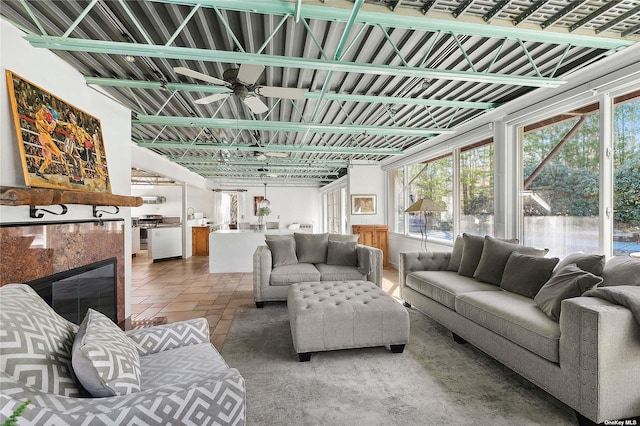 living area featuring stone tile flooring and a ceiling fan