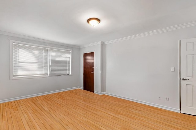 unfurnished room with baseboards, ornamental molding, and light wood finished floors