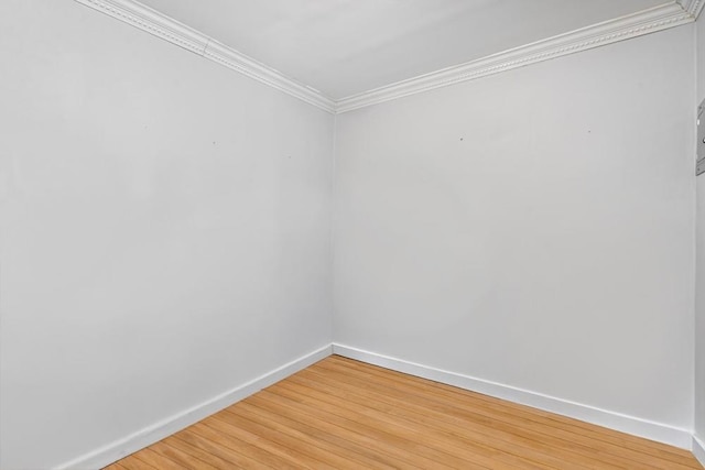 unfurnished room with light wood-type flooring, baseboards, and ornamental molding