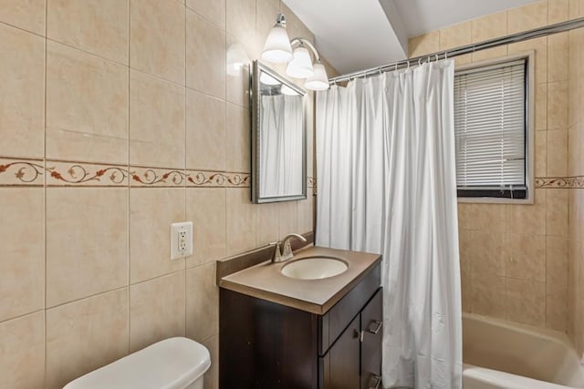 bathroom featuring tile walls, vanity, toilet, and shower / tub combo