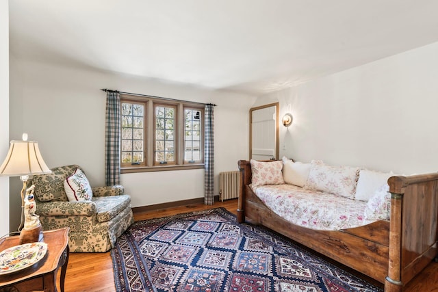 living area featuring radiator heating unit, wood finished floors, and baseboards