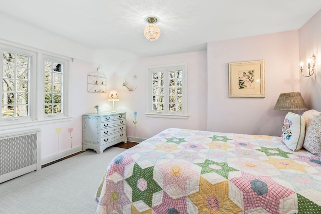 bedroom with radiator, baseboards, and carpet floors