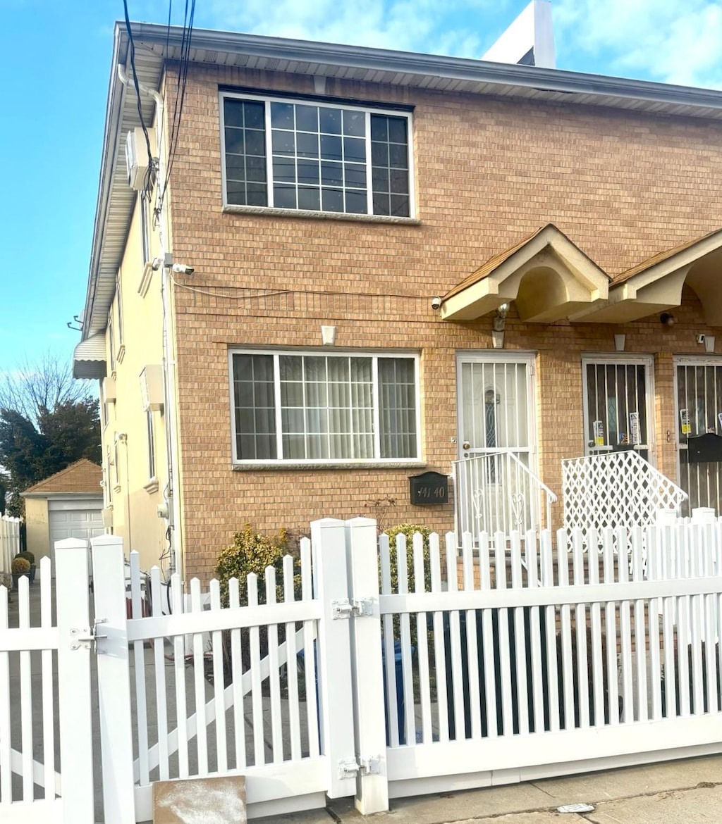 view of front of home featuring a fenced front yard, brick siding, and a gate