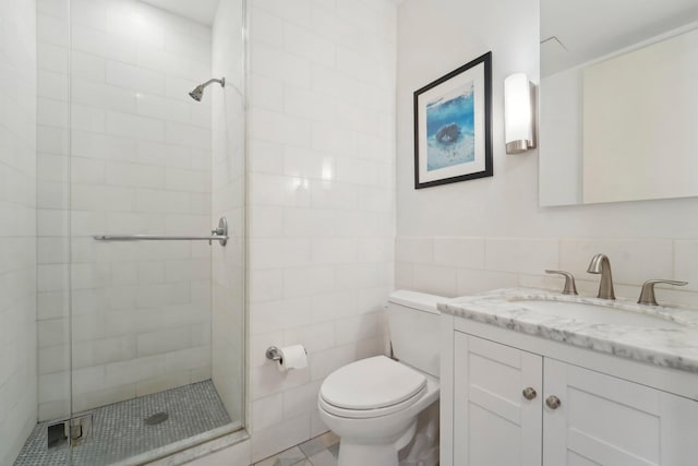 full bathroom featuring vanity, toilet, tile walls, and a shower stall