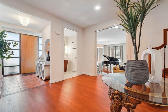 entrance foyer featuring a notable chandelier, baseboards, and wood finished floors