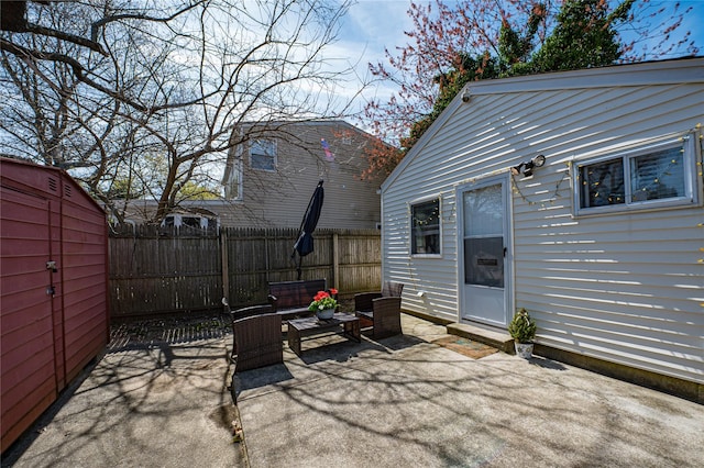 view of patio / terrace featuring an outbuilding, fence, and an outdoor living space