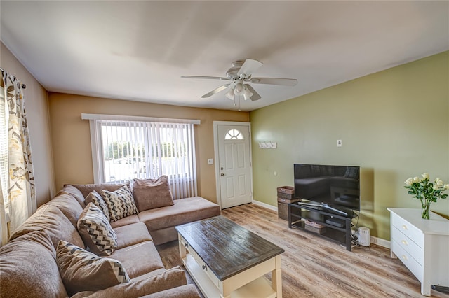 living room featuring baseboards, light wood-style flooring, and a ceiling fan