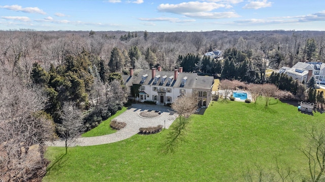 birds eye view of property featuring a forest view