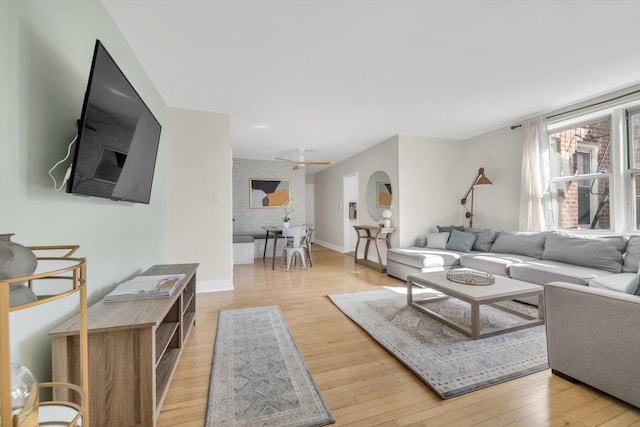 living area with ceiling fan, baseboards, and hardwood / wood-style floors