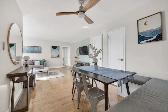 dining area featuring baseboards, a ceiling fan, and light wood-style floors