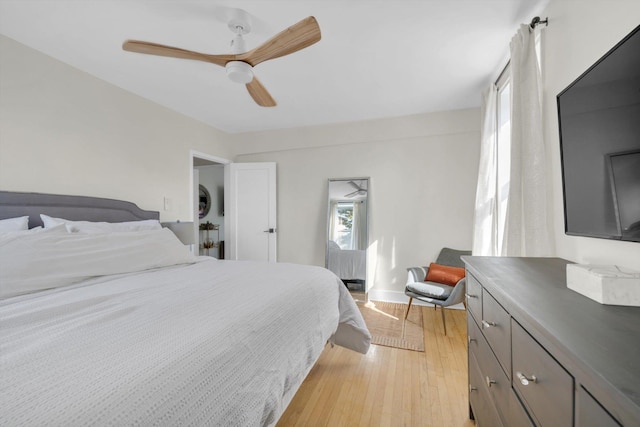 bedroom with light wood-style flooring, baseboards, and ceiling fan