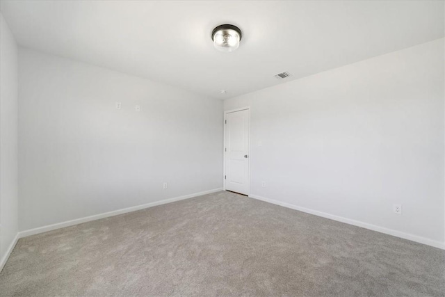 spare room with visible vents, carpet flooring, and baseboards