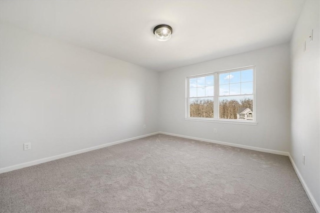 carpeted empty room featuring baseboards