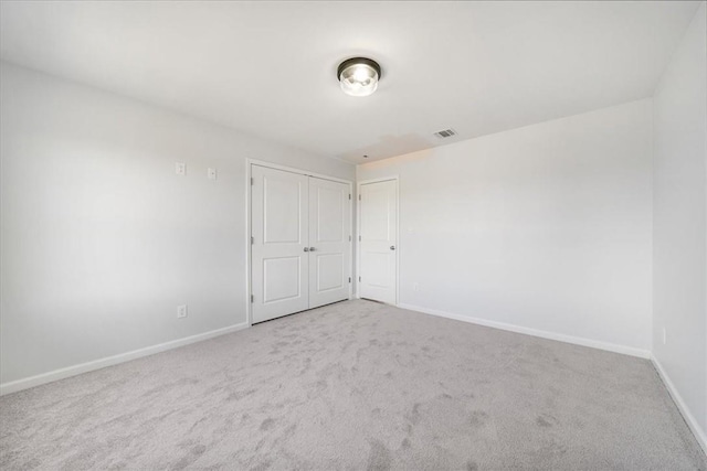 empty room featuring visible vents, baseboards, and carpet floors