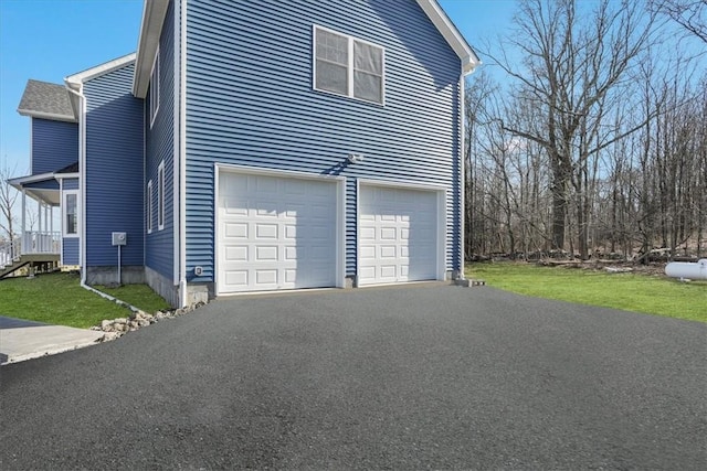 view of property exterior with aphalt driveway, an attached garage, and a lawn