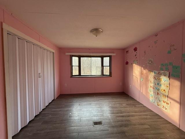 unfurnished bedroom featuring visible vents and wood finished floors