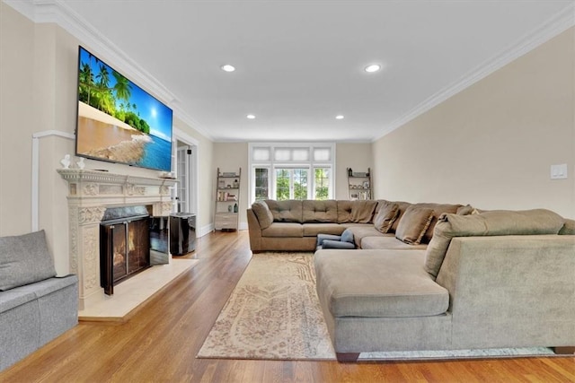 living area featuring ornamental molding, wood finished floors, recessed lighting, a premium fireplace, and baseboards