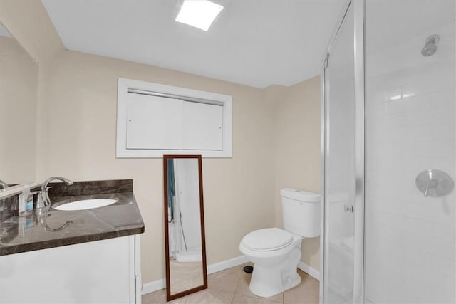 bathroom with vanity, baseboards, tile patterned flooring, a shower stall, and toilet