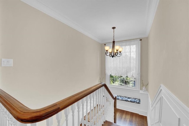 staircase featuring an inviting chandelier, crown molding, and a wealth of natural light