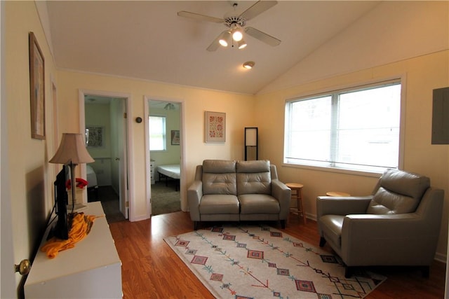 living area featuring a ceiling fan, vaulted ceiling, wood finished floors, and baseboards