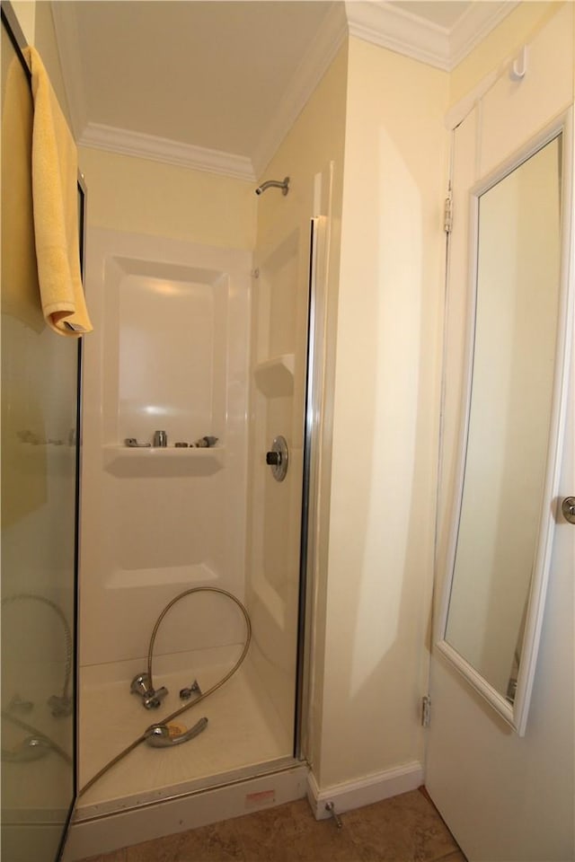 bathroom featuring a stall shower, baseboards, and ornamental molding