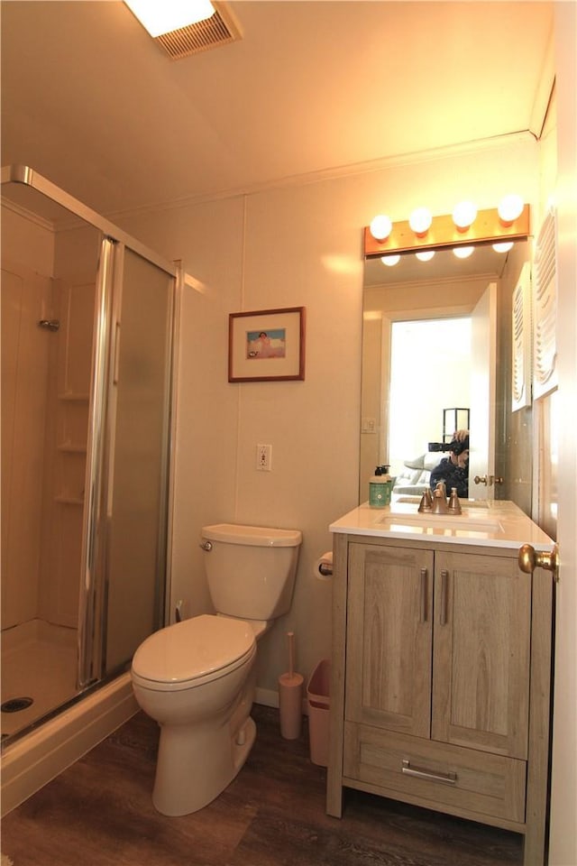 full bath with a shower stall, toilet, vanity, and wood finished floors