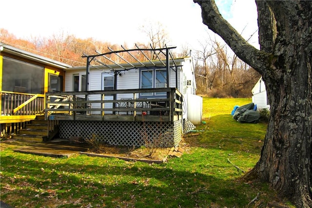 back of property featuring a lawn and a deck