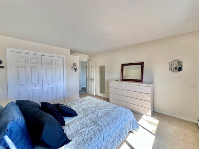 carpeted bedroom featuring a closet and baseboards