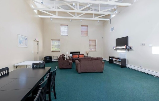 living room featuring carpet flooring, visible vents, and a towering ceiling