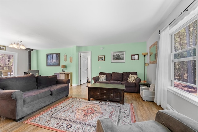 living room with wood finished floors, a chandelier, and a wealth of natural light