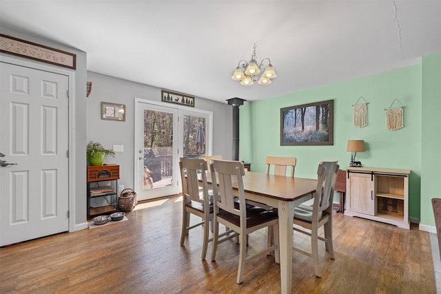dining space with baseboards, wood finished floors, and a chandelier