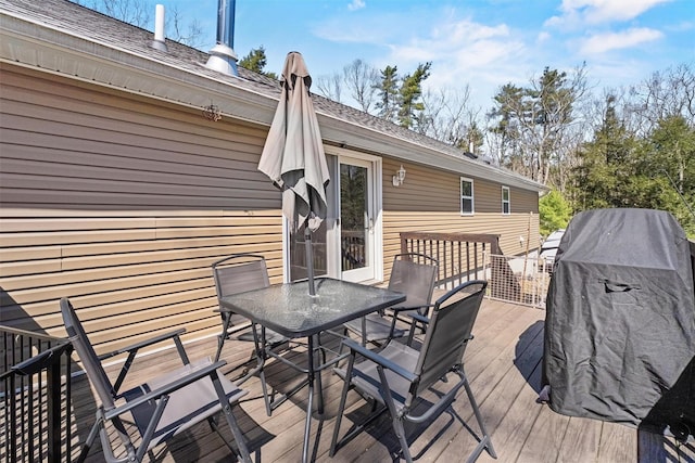wooden deck featuring a grill and outdoor dining space