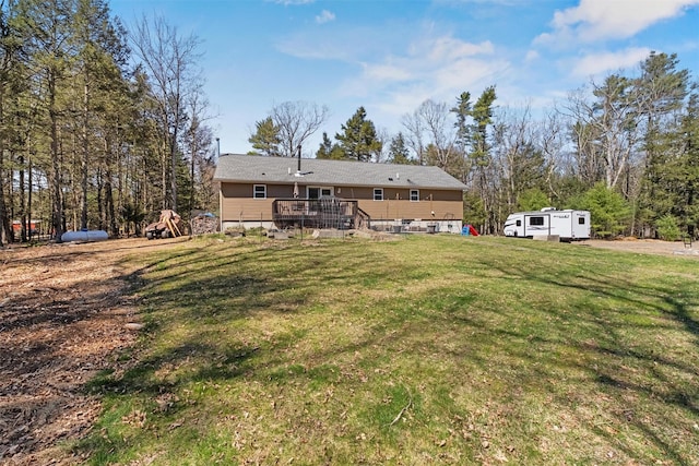rear view of house with a wooden deck and a yard