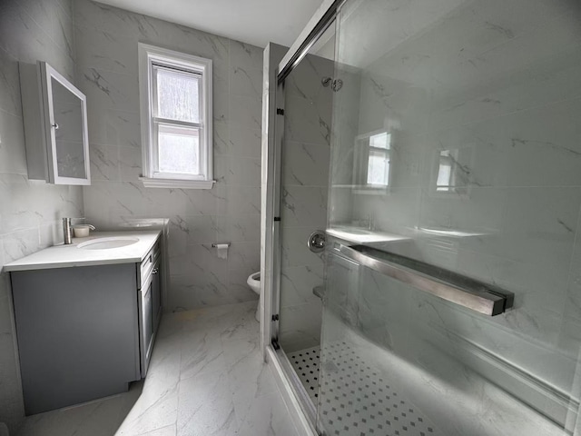 bathroom with a marble finish shower, toilet, marble finish floor, and vanity