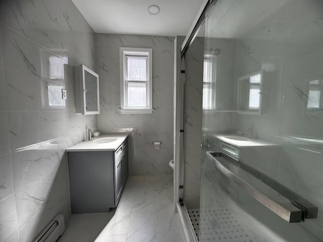 full bath with baseboard heating, marble finish floor, a stall shower, and vanity