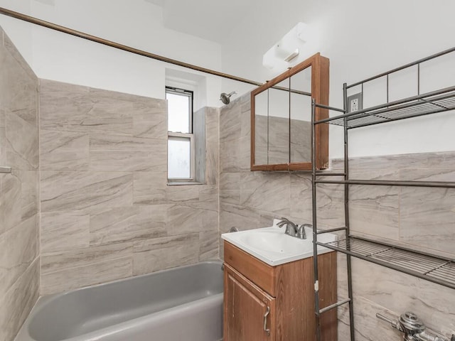 full bathroom featuring vanity, tile walls, and bathing tub / shower combination