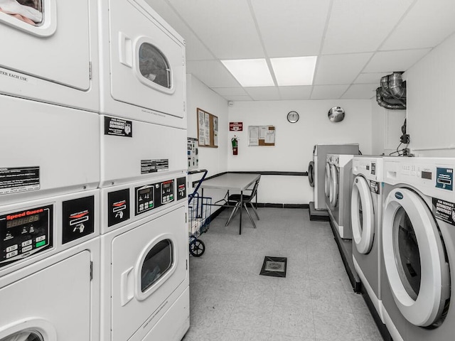common laundry area featuring stacked washer / drying machine, light floors, and washing machine and dryer